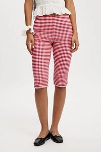 Detailed view of red and white plaid cropped pants featuring elegant white lace trim at the hem