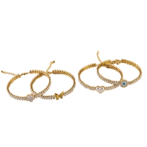 Set of four gold bracelets featuring clover, butterfly, heart, and evil eye pendants