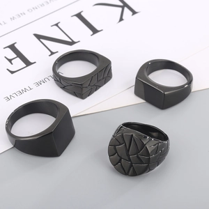 Set of four matte black stainless steel signet rings with geometric and smooth textures