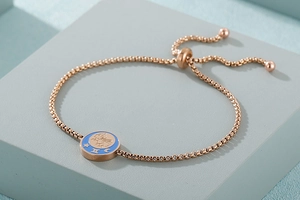 Dettaglio del bracciale zodiaco Gemelli in oro rosa con disco smaltato blu e catena regolabile