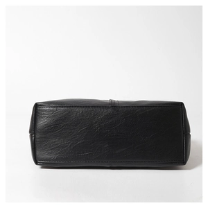 Close-up of black PU leather handbag bottom with lychee texture and reinforced stitching