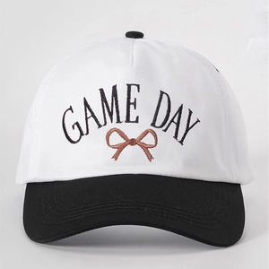 Detail of GAME DAY embroidery and brown bow on black and white canvas baseball cap