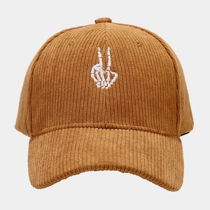 Detailed view of the corduroy fabric texture and white skeleton hand embroidery on the cap