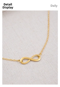 Macro detail of golden infinity symbol pendant necklace on soft textured fabric