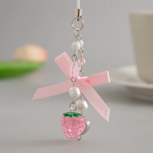 Detail of pink strawberry pendant with ribbon bow and imitation pearl beads keychain