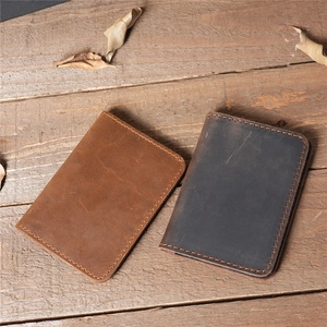Detailed close-up of handmade crazy horse leather wallet with vintage stitching on wood