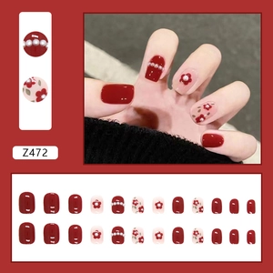 Red and pink press-on nails set with pearl and flower patterns for festive New Year style
