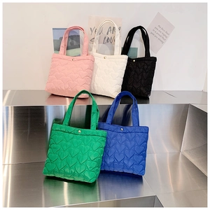 Collection of heart-quilted nylon tote bags in five trendy colors on display steps