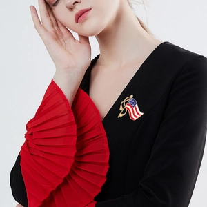 USA flag brooch with gold tassels on black dress, elegant Independence Day jewelry piece