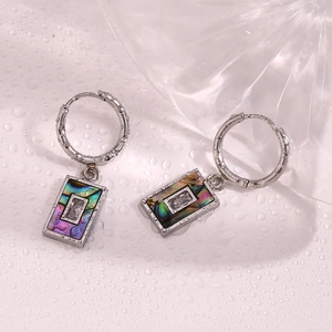 Close-up of rectangular abalone shell pendant earrings with zircon on water drop background