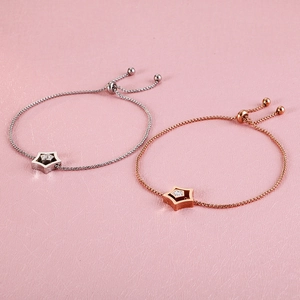 Detail of adjustable star charm bracelets in silver and rose gold with zircon stones