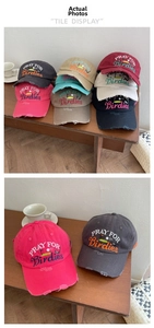 Close-up of distressed brim details and embroidered lettering on cotton baseball caps