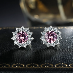 Macro shot of silver sunflower stud earrings with pink zircon and white pavé stones