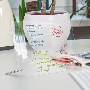 Detail of transparent acrylic weekly planner board with markers on a wooden desk