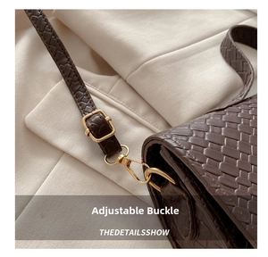 Close-up of golden adjustable buckle and swivel hook on brown woven crossbody bag