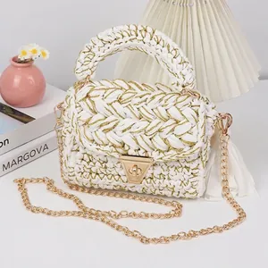 Close-up of handmade crochet crossbody bag with gold lock and tassel detail