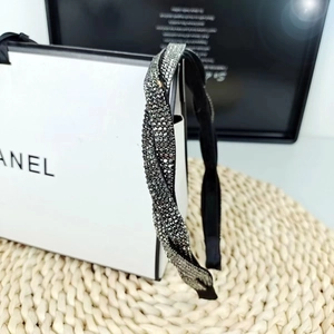 Detail of black braided headband with sparkling metallic rhinestones for elegant styling