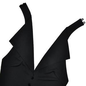 Détail d'une robe noire à col en V avec fermeture à boutons, larges bretelles et col