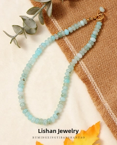 Detailed close-up of light blue aquamarine beaded necklace with elegant gold toggle clasp
