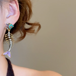 Detailed close-up of fishbone earrings with colorful enamel and inlaid white pearls