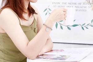 Silver tree of life coin pendant on chunky chain bracelet worn by a model in lifestyle setting