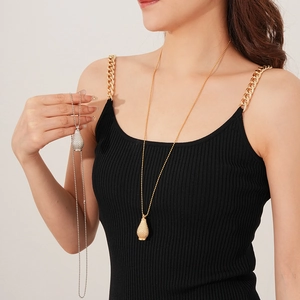 Detail of woven bottle pendant long chain necklace in gold and silver finish for women