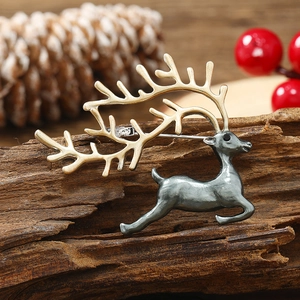 Macro shot of a 925 sterling silver deer brooch on wood with gold and silver details