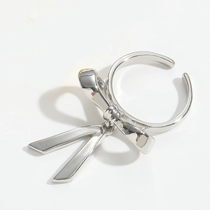 Macro detail of silver bow ring showing elegant polished finish and curved metal design