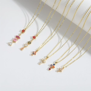 Set of minimalist gold cross and heart necklaces with colorful zircon stones in bright light