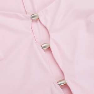 Detailed close-up of textured silver metal buttons on a pink long sleeve square neck dress