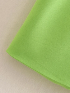 Macro view of bright green twill fabric texture showing high-quality woven fibers