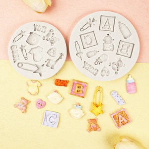 Macro detail of silicone molds and assorted baby-themed fondant shapes for cake decoration