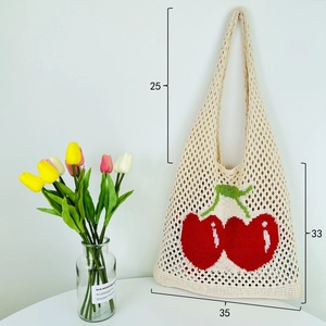 Detail view of large knit tote bag with cherry pattern and 35x33cm size dimensions