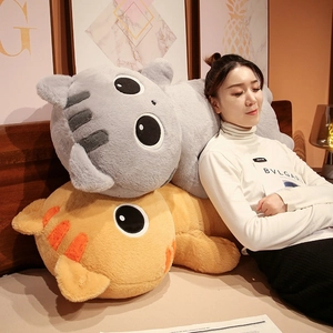 Cozy close-up of large plush cat pillows in grey and orange on a soft bed
