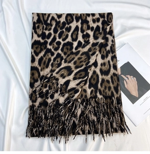 Close-up of leopard print scarf texture with fringes on a minimalist backdrop