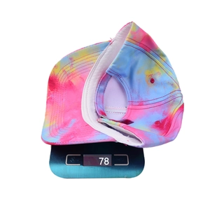 Tie-dye baseball cap in vibrant pink, blue, and yellow weighing 78g on a scale