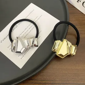 Close-up of geometric gold and silver metallic ponytail cuffs with black elastic bands