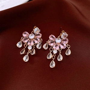 Detail of gold floral tassel earrings with pink zircon and teardrop crystal pendants