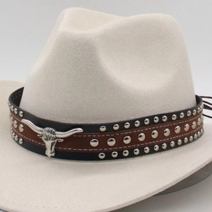 Close-up of a beige cowboy hat featuring a brown leather band with silver bull head charm
