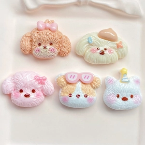 Close-up of colorful resin dog and cat charms on a white ceramic tray for DIY crafts
