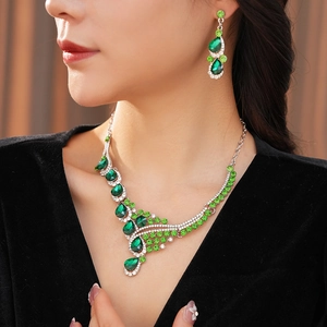Close-up of vintage teardrop jewelry set featuring green crystals on a model