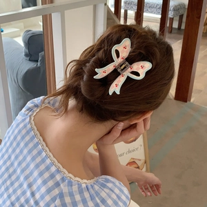 Bow hair claw clip with cherry pattern and pink checkered print on model's hair