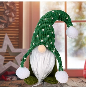 Detailed knit texture of green Christmas gnome doll with white fuzzy pompoms and soft beard