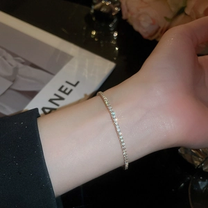 Close-up of a sparkling silver tennis bracelet with round zircon stones on a wrist