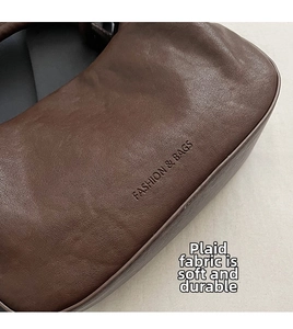 Dettaglio della pelle litchi marrone scuro con scritta Fashion & Bags in rilievo