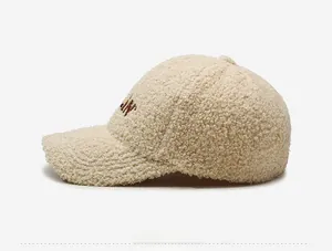 Detail of off-white sherpa fleece baseball cap with brown letter embroidery on the side