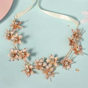 Macro view of gold metal floral headband with sparkling crystals and ivory ribbons