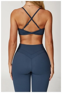Dettaglio del reggiseno yoga con schiena incrociata e leggings blu scuro opaco