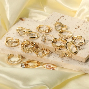 Ensemble de bagues dorées avec zircons et perles sur soie élégante et pierre