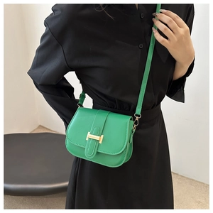 Detail shot of the bright green square crossbody bag featuring a golden H-shaped clasp buckle